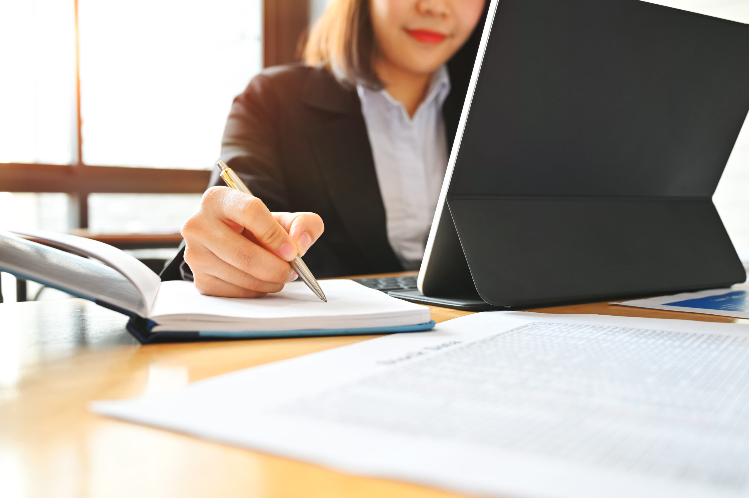 Audit business woman working with notebook and tablet on desk